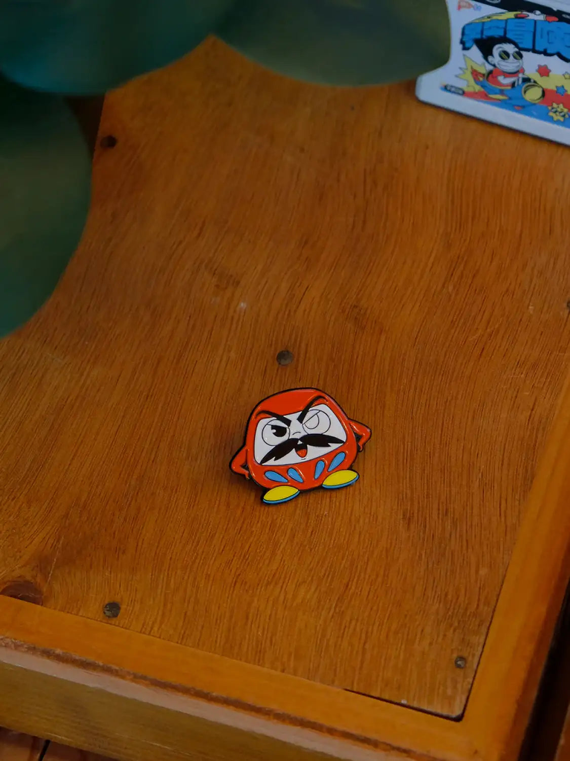 Pin's japonais Daruma, porté sur un tissu